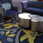 Custom-designed furniture and rugs include stainless steel nested tables